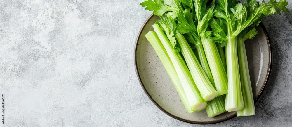 Fototapete Braised celery on a plate against a light stone background with ample free text space Top view flat lay