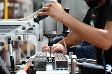 worker using drill in factory