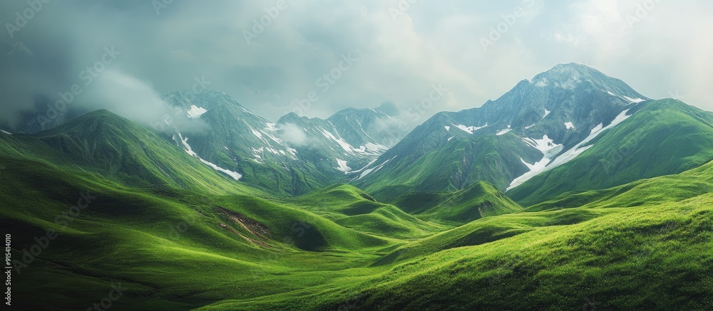 Fototapete Lush green hills and mountains with patches of remaining snow. with copy space image. Place for adding text or design