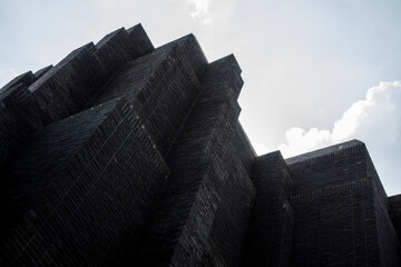 The image shows the modern Gdańsk theater building with its distinctive architectural design against a backdrop of a cloudy sky.