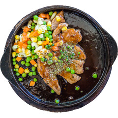 Black pepper pork steak topped with peas, carrots and corn, served on a hot plate on a white background.