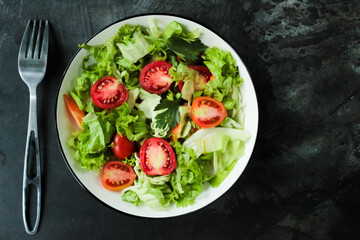 a bowl of vegetable salad and a fork on the table