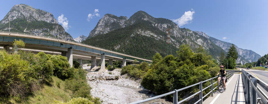 woman with e-bike on the alpe adria cycle route ( Pontebanna )  through the Val Canale in Italy