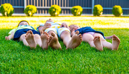 close-up of children's feet running on green grass in summer.