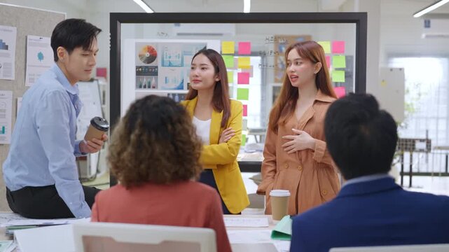 Modern office with an Asian business team sharing creative ideas. Collaborative professionals brainstorming strategies in a sleek, innovative environment, promoting teamwork and diversity