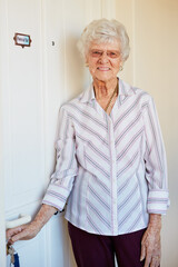 Senior woman, portrait and door in retirement home with glasses for peace, health and positive mood. Elderly person, face and happy in nursing house with keys for wellbeing, calm and gratitude