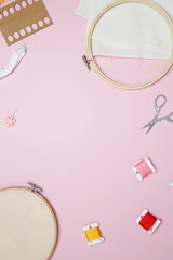 Embroidery set fot stitching. Beige cotton cloth in embroidery hoop on pink background with fabric,...