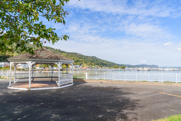 Empty gazebo on a waterfront on a might river on a sunny autumn day. A river harbour overlooked by...