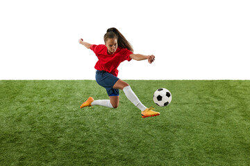 Obraz premium Athletic young woman, skilled bombardier, kicking ball with leg in mid-air aiming straight at opponent's goal green grassed stadium. Concept of women and sport, team games, tournament, victory, action