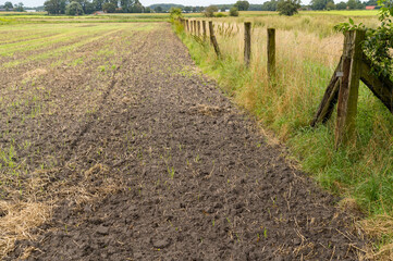 harvested field with fence in autumn