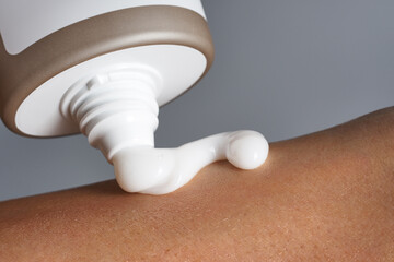 Squeezing body cream to the skin.. Natural cosmetics for skin care concept.