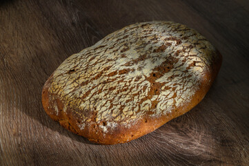 Wheat artisan sourdough bread on a wooden table black background.