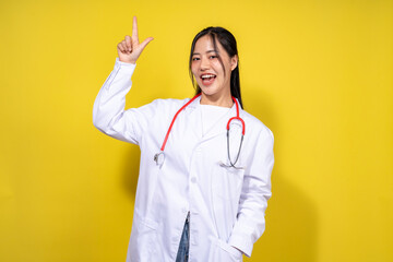 A woman in a white lab coat is pointing her finger up