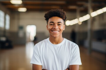 Obraz premium Portrait of a smiling male African American teenager in basketball gym