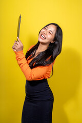 A woman is smiling and holding a knife in her hand