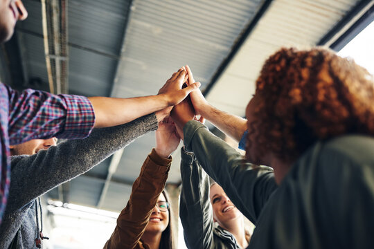 Students, group or high five at university with support for study motivation or academic collaboration. Friends, diversity people or hands together on campus for solidarity in learning or scholarship