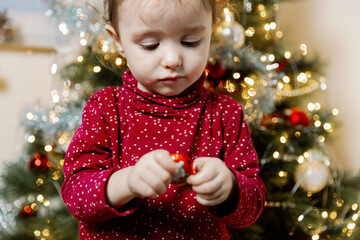 A baby girl unwraps a gift from a wall advent calendar.