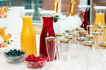 bright table with champagne, juice and fruit for mimosas