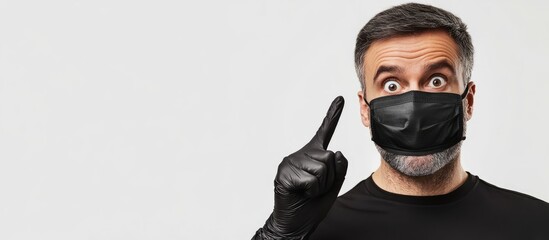 Concept of coronavirus lifestyle and quarantine Portrait of a surprised attractive middle aged man looking and pointing to the right dressed in a black medical mask and gloves set against a white bac
