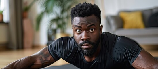 Bi racial man performing a plank exercise on a fitness mat in his living room. with copy space image. Place for adding text or design