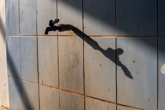 A public water tap for ablution with its shadow on the wall