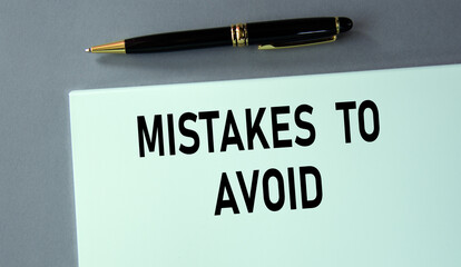 MISTAKES TO AVOID - words on a piece of paper with a pen on a gray background