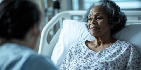 Obraz premium A woman sits beside a man in a hospital bed, offering support and care