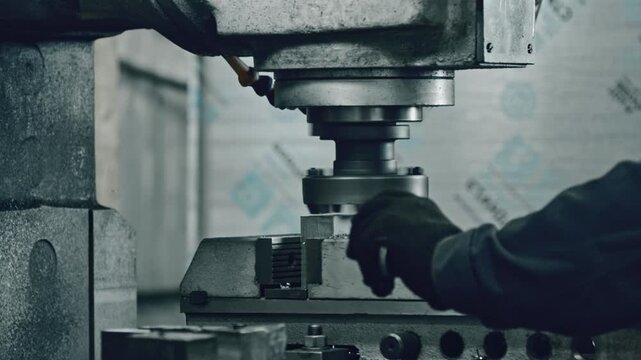 Experienced technician skillfully operates an industrial milling machine in a workshop, adjusting components meticulously. Precision engineering and manufacturing process depicted clearly