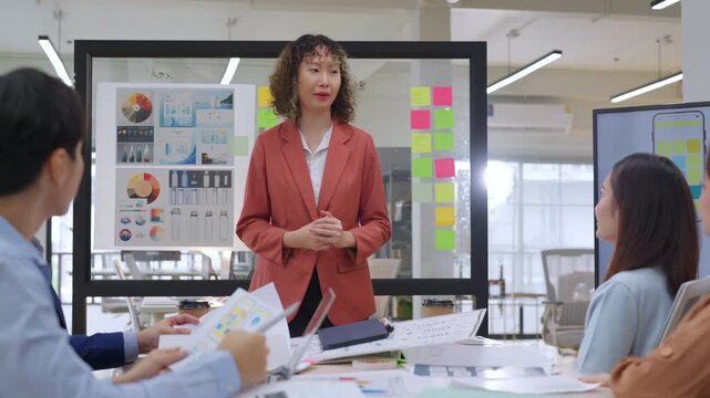 Modern office with an Asian business team sharing creative ideas. Collaborative professionals brainstorming strategies in a sleek, innovative environment, promoting teamwork and diversity