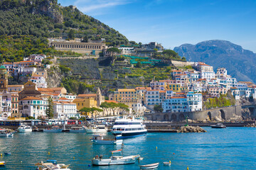 Picturesque view of Amalfi, Italy, with colorful houses, blue waters of Mediterranean Sea and ripe lemons in foreground. Amalfi coast is most popular travel and holiday destination in Europe