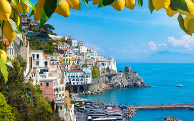 Stunning view of Amalfi, Italy, with colorful houses, clear blue waters of Mediterranean Sea and vibrant lemons in foreground. Amalfi coast is most popular travel and holiday destination in Europe