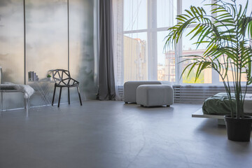 stylish discreet interior of the sleeping area in a modern studio in white-gray colors with green plants. daylight and no people inside