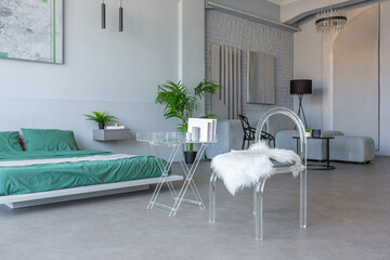 stylish discreet interior of the sleeping area in a modern studio in white-gray colors with green...