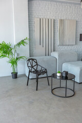 stylish discreet interior of the sleeping area in a modern studio in white-gray colors with green plants. daylight and no people inside