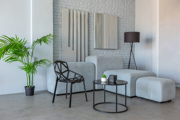 stylish discreet interior of the sleeping area in a modern studio in white-gray colors with green plants. daylight and no people inside