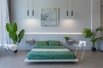 stylish discreet interior of the sleeping area in a modern studio in white-gray colors with green...
