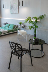 stylish discreet interior of the sleeping area in a modern studio in white-gray colors with green plants. daylight and no people inside