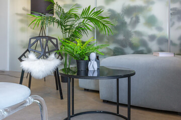 a spectacular area with a table and chair against the backdrop of a transparent designer partition behind which there are plants