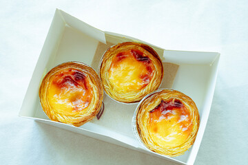 Pastel de nata or Pastel de Belém. Bright, golden, crispy traditional Portuguese dessert on a...