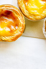 Pastel de nata or Pastel de Belém. Bright, golden, crispy traditional Portuguese dessert on a...
