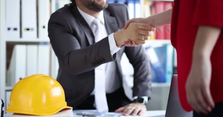 Construction contractor shaking hands with client while concluding contract. Successful construction deal concept