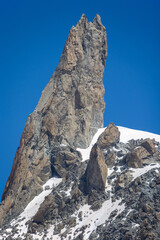 view of the mountain peak dent du geant near mont blanc under a sunny blue sky and some climbers