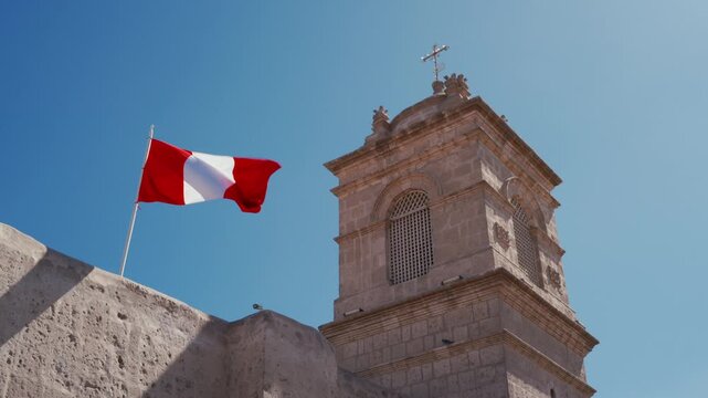 A Peruvian flag flutters in the wind above Santa Catalina Monastery in Arequipa, Peru