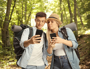 Young couple hikers with smartphones