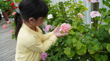 An Asian girl in a yellow jacket is holding beautiful flowers
