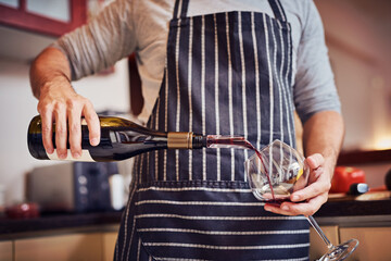 Hands, wine bottle and person with apron for cooking, culinary hobby or beverage for relaxing. Alcohol, drink and glass in kitchen for break in home or apartment to prepare dinner or lunch meal