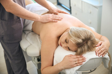 Obraz premium Physical therapist relaxing patient thoracic spine muscles