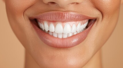 Obraz premium Close-up of a smiling woman showing perfect white teeth and healthy lips against a soft background.
