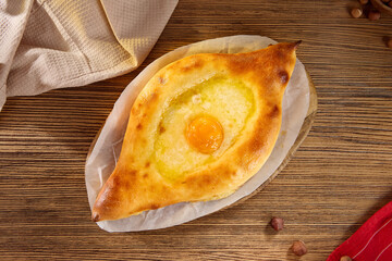 Adjarian Khachapuri with Egg – Traditional Georgian Cheese and Egg Bread on Rustic Wooden Background