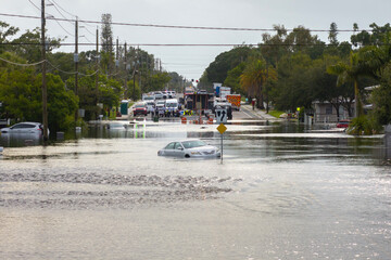 Fototapeta premium Flooded Florida street with stuck car after hurricane Debby rainfall surrounded with water. Consequences of natural disaster